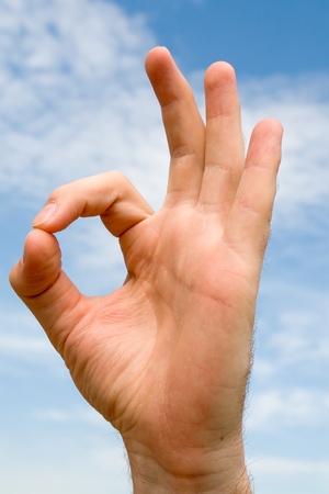 OK. hand gesture with blue sky at backgroundの写真素材