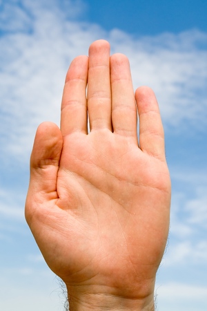 oath. hand gesture with blue sky at backgroundの写真素材