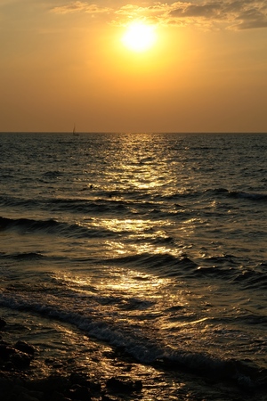Sea waves with sunset at backgroundの写真素材