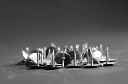 Heap of metal pushpins on a black backgroundの写真素材