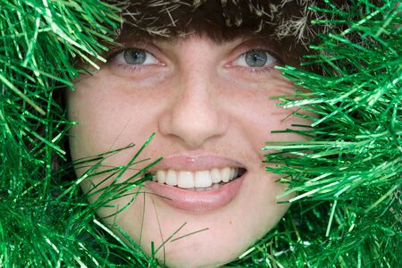 Christmas. New Year.  Beautiful smiling woman with tinsel.の写真素材