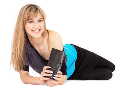 Smiling young woman with handbag lies against isolated white background