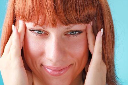 Beautiful red haired woman close up on a blue backgroundの写真素材