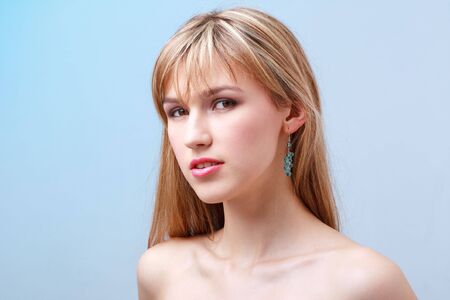 Attractive young woman on a blue background.の写真素材