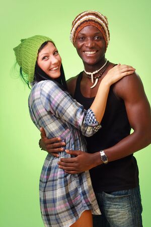 Happy couple. White woman and black man on a green backgroundの写真素材