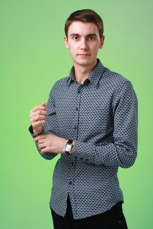 Attractive young man standing against green backgroundの写真素材