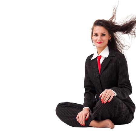 Attractive woman with hair flying, sitting on a white background with copyspaceの写真素材