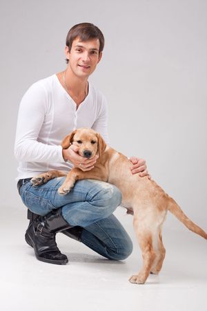 handsome man with dog on a gray background.の写真素材
