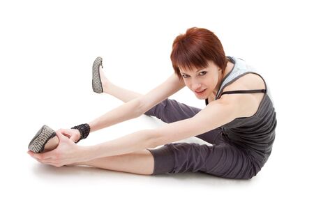 gymnastics. young woman sitting on a white background.の写真素材