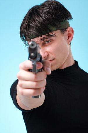 Aiming. Man with gun close up on a blue background.の写真素材