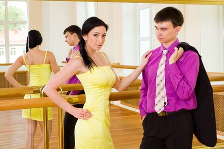 Portrait of a beautiful young couple in the ballroom on a mirror backgroundの写真素材