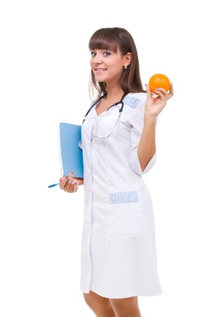 Smiling doctor with orange, isolated on a white background with copyspaceの写真素材