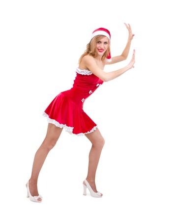 beautiful sexy girl wearing santa claus clothes pushing something against isolated white backgroundの写真素材