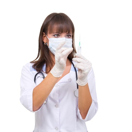 Doctor wearing a mask with stethoscope and syringe on a white backgroundの写真素材