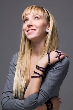 Smiling young woman on a grey background.の写真素材