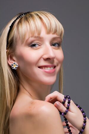 Closeup portrait of a smiling young woman on a grey background.の写真素材