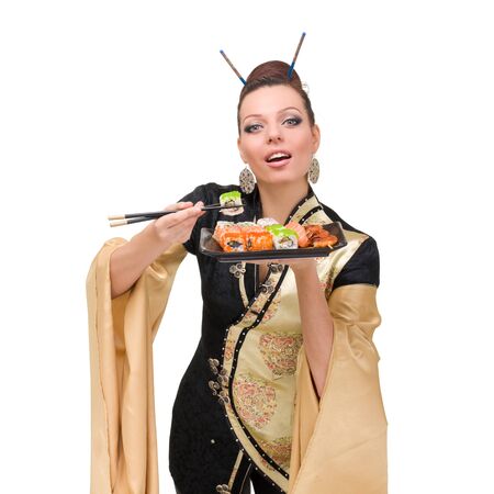 Woman wearing a traditional dress eating sushi, isolated on white background.の写真素材
