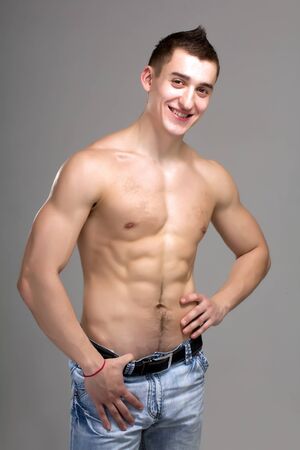 sexy muscular man posing on a gray backgroundの写真素材