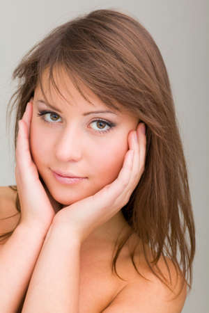Closeup portrait of a beautiful young woman on a gray backgroundの写真素材
