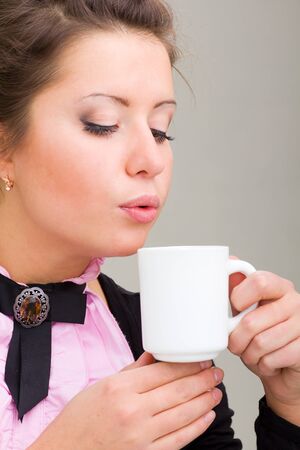 Beautiful young woman enjoying a cup of coffeeの写真素材