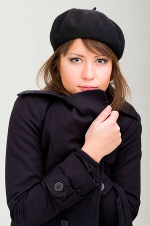 woman wearing in a coat and beret on a gray backgroundの写真素材