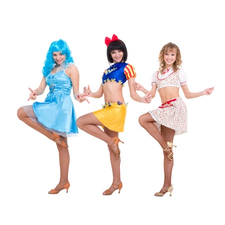 Three smiling girls dressed in doll clothes dancing on a white backgroundの写真素材