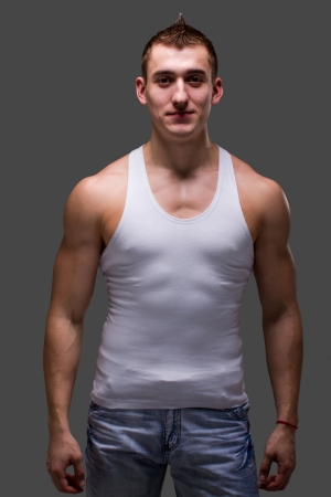 Young muscular man posing on a gray backgroundの写真素材