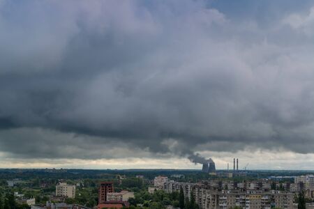 Smoking pipes of thermal power plant against storm sky
