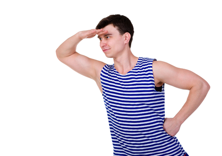 Young man in a striped vest T-shirt peering, isolated on white backgroundの写真素材