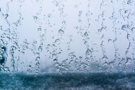 snow and water drops on the window glass