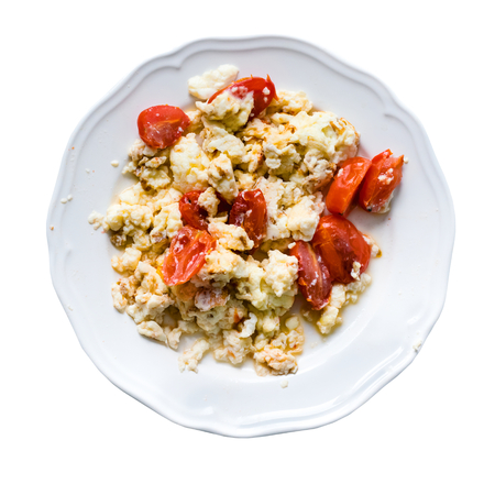Fried eggs with slices of tomatoes in plate isolated on whiteの写真素材
