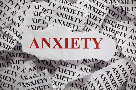 Torn pieces of paper with the word "Anxiety". Concept Image. Close-up.の写真素材