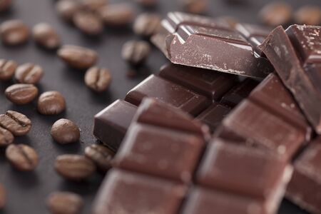 Chocolate and coffee beans on a black background. Close-up.