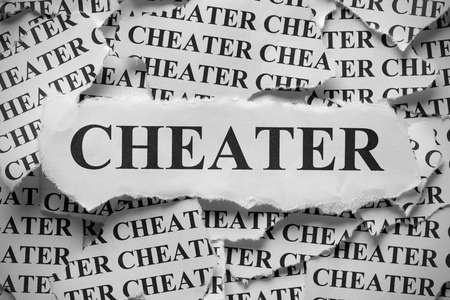 Torn pieces of paper with the word "Cheater". Black and White. Close-up.の写真素材