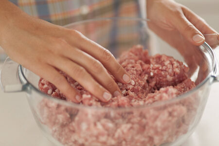 Woman preparing minced meat in kitchen.の写真素材