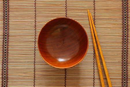 Empty wooden bowl and chopsticks.の写真素材