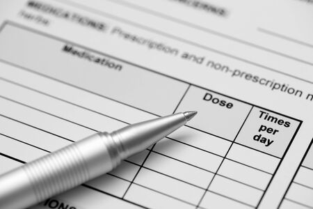 Adult medical history form (medication record) and ballpoint pen. Black and White. Close-up.の写真素材