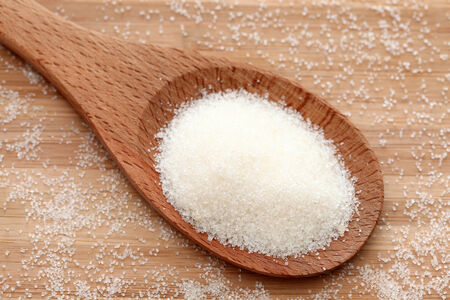 Sugar in a wooden spoon. Close-up.の写真素材