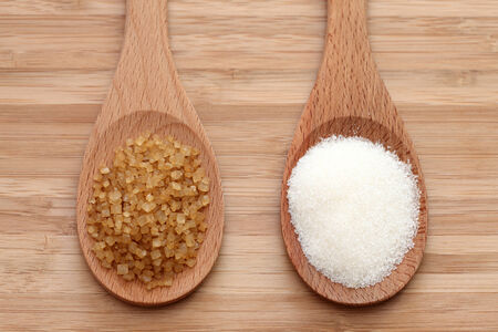 White and brown sugar in a wooden spoons. Close-up.の写真素材