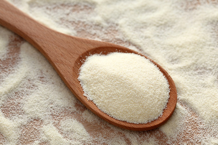 Semolina in a wooden spoon. Close-up.の写真素材