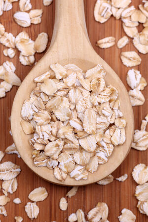 Rolled oats (oat flakes) in a wooden spoon. Close-up.の写真素材