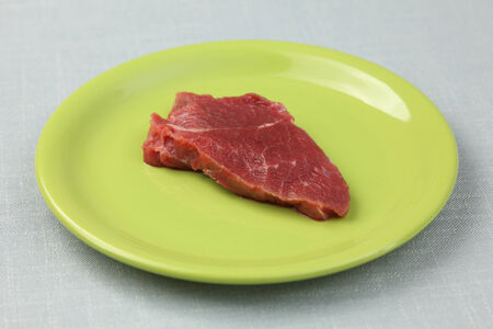 Raw fillet beef steak on a green plate. Close-up.の写真素材