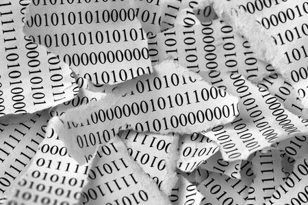 Torn pieces of paper with a binary code. Black and White. Close-up.の写真素材