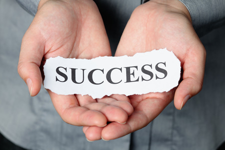 Torn piece of paper with the word "Success" in the woman's palms.の写真素材