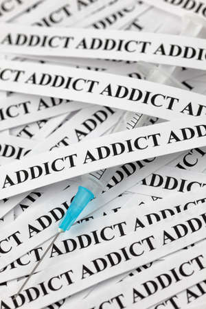 Syringe and paper with the words "Addict". Concept Image. Selective focus. Close-up.の写真素材