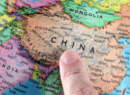 Finger pointing to China on a globe. Close-up.の写真素材