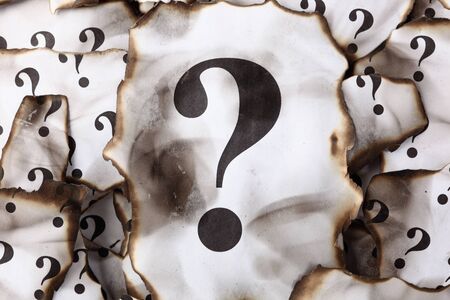 Burnt Question Marks. Burnt pieces of paper with the question mark. Close-up.の写真素材