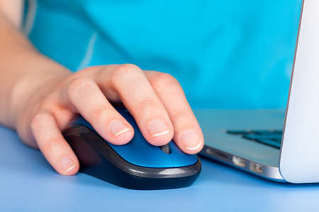 Womanâ€™s hand using computer mouse. Closeup.