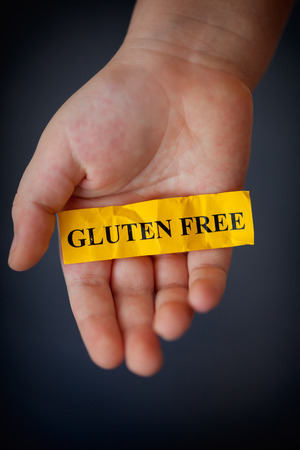 Gluten Free Concept.
Childâs hand holds yellow piece of paper with word Â«Gluten FreeÂ».の写真素材