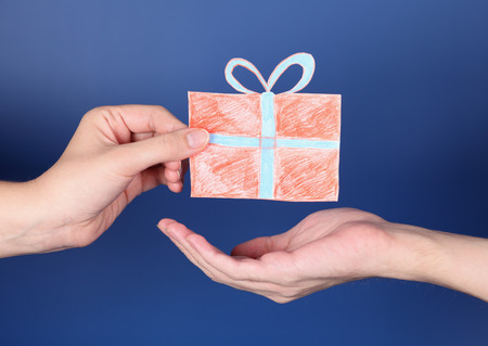 Hand giving a present to another one. Gift box is paper cutout.の写真素材